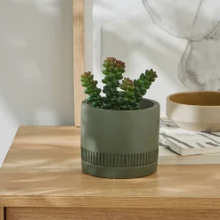 Groene kunstplant en pot in cement