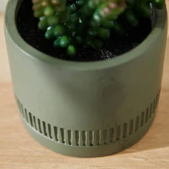 Groene kunstplant en pot in cement